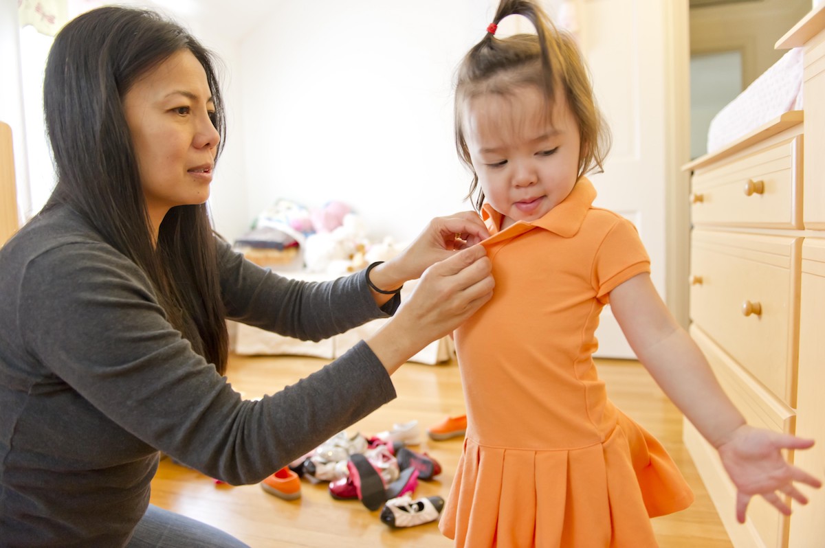 Woman helping dress her daughter