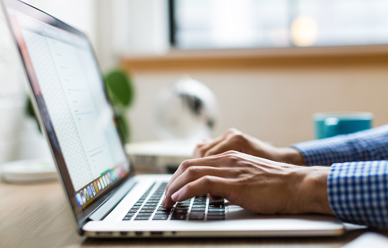 man typing on laptop